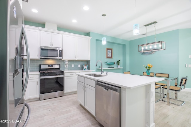 kitchen with pendant lighting, white cabinetry, stainless steel appliances, and sink