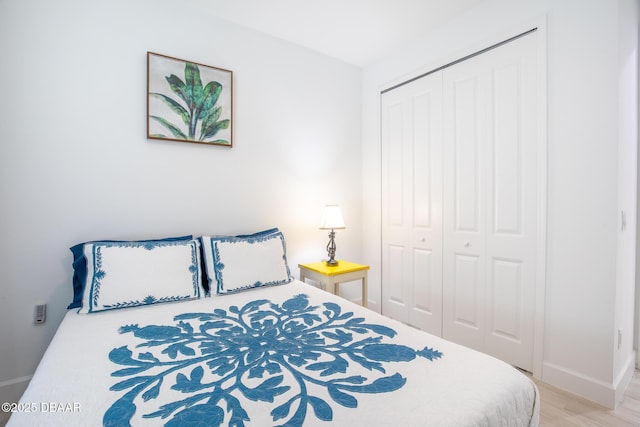 bedroom with light wood-type flooring and a closet