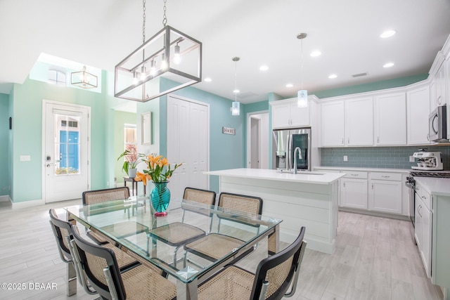 dining area with sink and light hardwood / wood-style floors