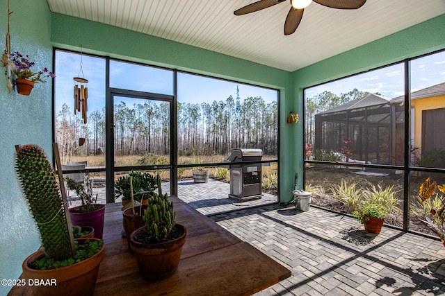 sunroom with a healthy amount of sunlight and ceiling fan