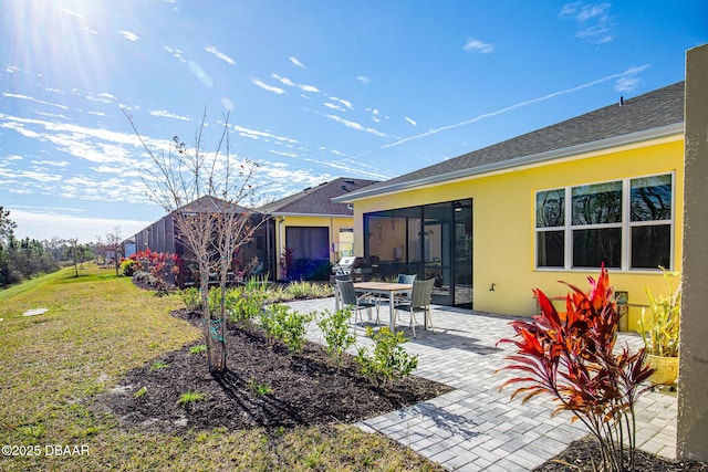 rear view of property with a lawn and a patio