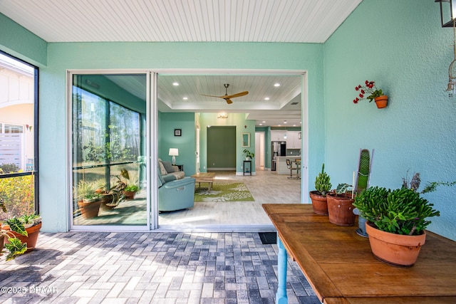 sunroom / solarium featuring a wealth of natural light and a raised ceiling