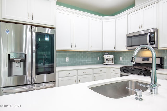 kitchen featuring tasteful backsplash, appliances with stainless steel finishes, and white cabinets