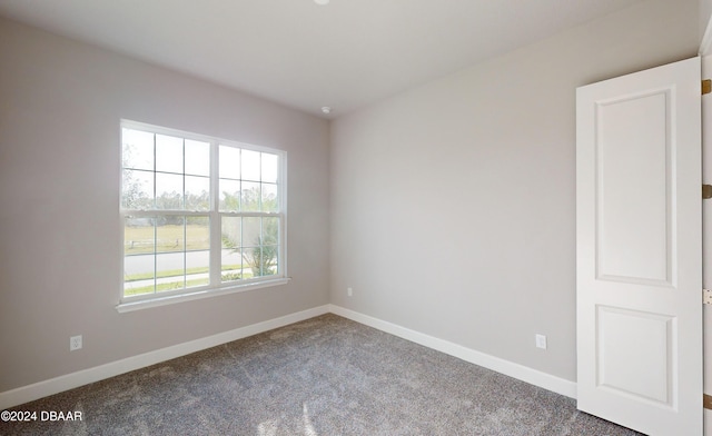 carpeted spare room featuring plenty of natural light