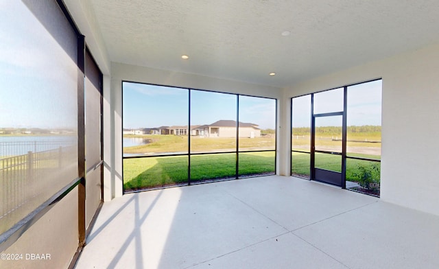 unfurnished sunroom with a water view