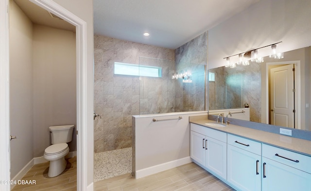 bathroom with vanity, toilet, and a tile shower