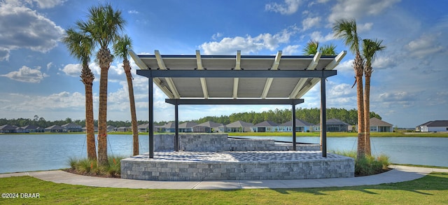 dock area featuring a lawn, a water view, and a hot tub