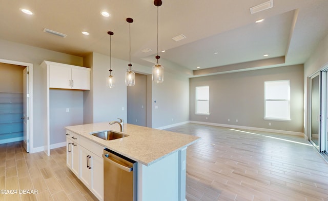 kitchen featuring white cabinets, stainless steel dishwasher, light stone countertops, and sink