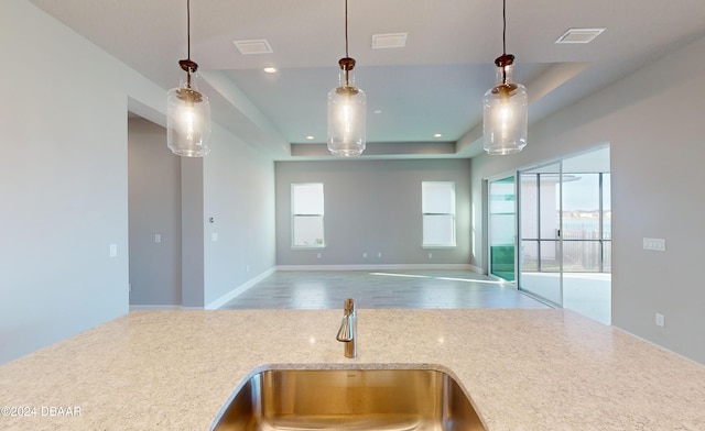 kitchen with decorative light fixtures, hardwood / wood-style flooring, a wealth of natural light, and sink