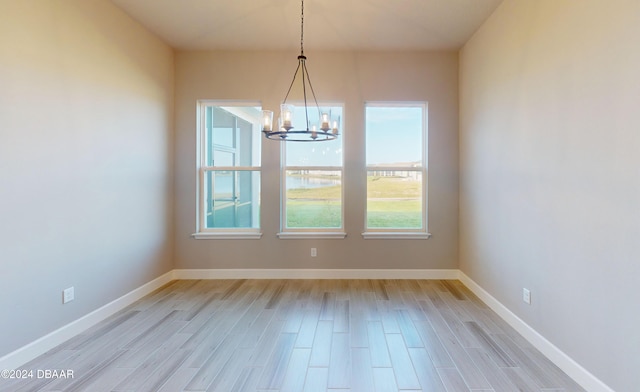 unfurnished dining area featuring a notable chandelier and light wood-type flooring