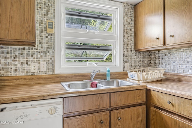 kitchen with a sink, backsplash, and dishwasher