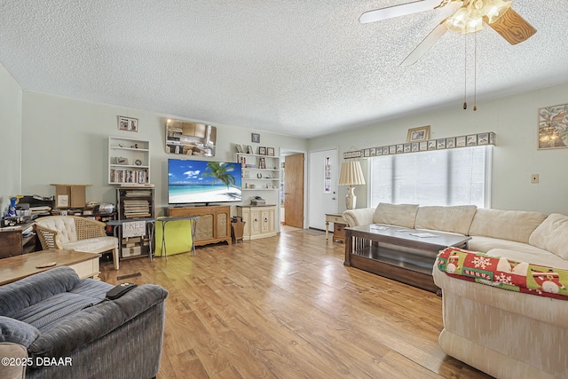 living area featuring a textured ceiling, ceiling fan, and wood finished floors