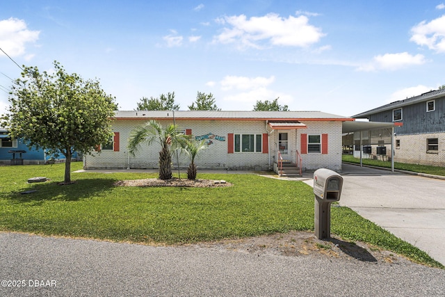 ranch-style home with a carport, driveway, a front lawn, and brick siding