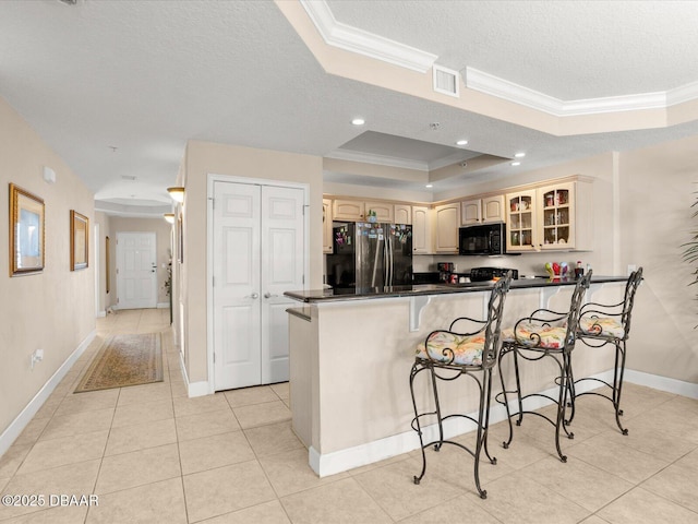 2403 S Atlantic Ave Unit 410, Daytona Beach, FL 32118 - kitchen with freestanding refrigerator, black microwave, ornamental molding, a peninsula, and a raised ceiling