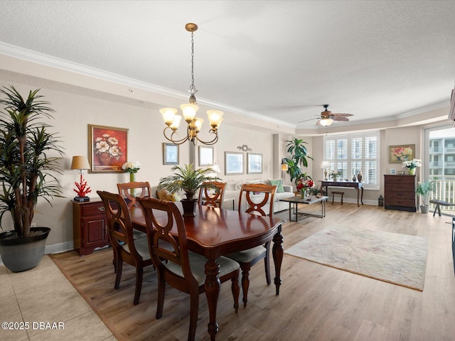 2403 S Atlantic Ave Unit 410, Daytona Beach, FL 32118 - dining area featuring ornamental molding, a ceiling fan, light wood-style flooring, baseboards, and a chandelier
