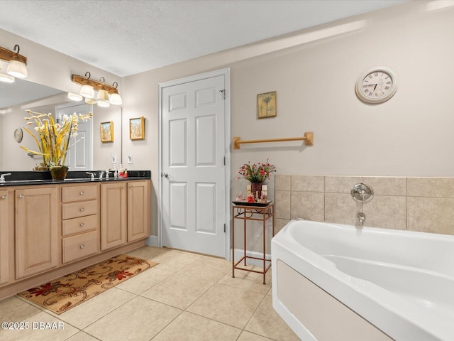 2403 S Atlantic Ave Unit 410, Daytona Beach, FL 32118 - bathroom with tile patterned flooring, a garden tub, double vanity, and a textured ceiling