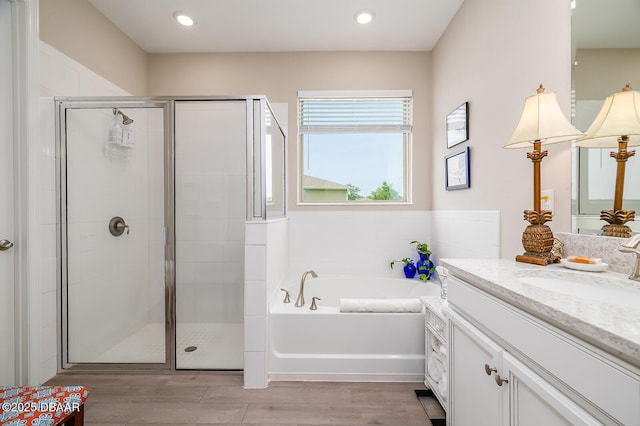 3013 Kenmare St, Ormond Beach, FL 32174 - full bath with vanity, a garden tub, a stall shower, wood finished floors, and recessed lighting