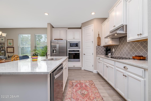3013 Kenmare St, Ormond Beach, FL 32174 - kitchen with appliances with stainless steel finishes, a sink, decorative backsplash, under cabinet range hood, and light wood-type flooring