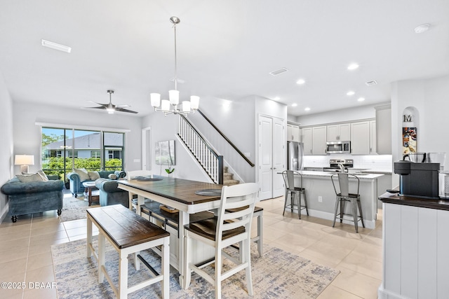 6423 Hanfield Ln, Port Orange, FL 32128 - dining room with light tile patterned floors, a chandelier, stairway, recessed lighting, and a ceiling fan