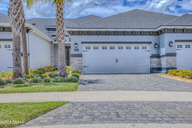 6423 Hanfield Ln, Port Orange, FL 32128 - view of front of home with stone siding, stucco siding, an attached garage, and decorative driveway