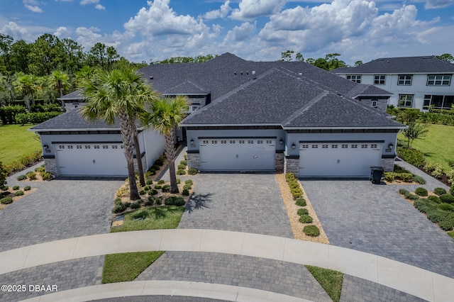 6423 Hanfield Ln, Port Orange, FL 32128 - view of front of home featuring a shingled roof, decorative driveway, an attached garage, and stone siding
