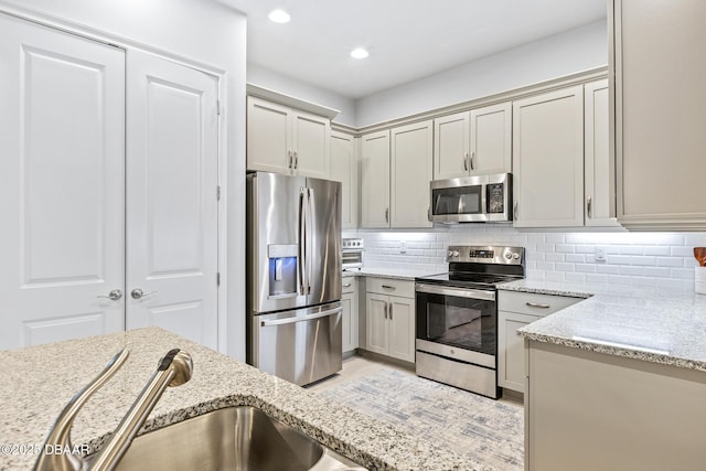 6423 Hanfield Ln, Port Orange, FL 32128 - kitchen with appliances with stainless steel finishes, decorative backsplash, light stone counters, recessed lighting, and gray cabinetry
