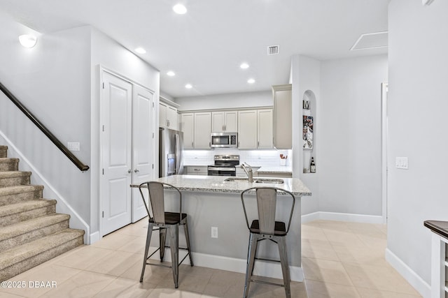 6423 Hanfield Ln, Port Orange, FL 32128 - kitchen with appliances with stainless steel finishes, a breakfast bar area, light stone countertops, light tile patterned floors, and recessed lighting