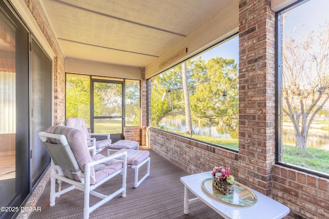 sunroom featuring a water view