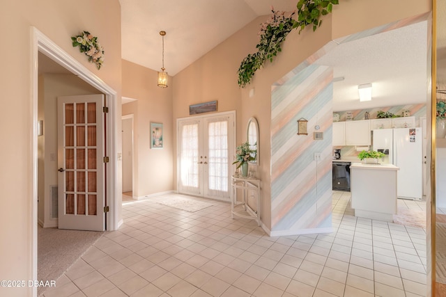 entrance foyer featuring high vaulted ceiling, light tile patterned floors, and french doors