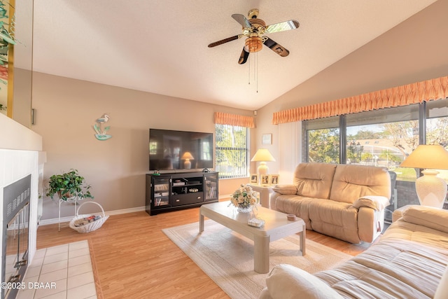 living room featuring ceiling fan, light hardwood / wood-style flooring, and high vaulted ceiling