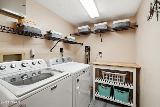 washroom featuring hardwood / wood-style floors, washer and dryer, and a textured ceiling