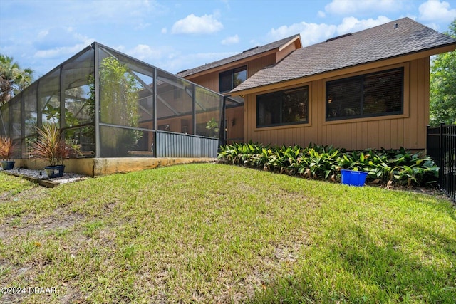 back of house with a lanai and a yard