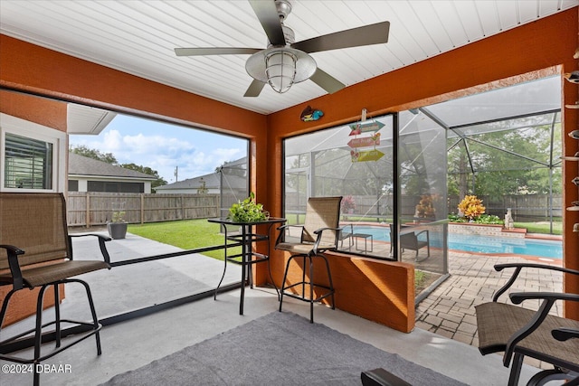 sunroom / solarium featuring a swimming pool, a healthy amount of sunlight, and ceiling fan