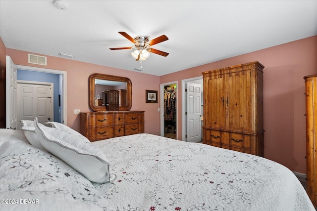 bedroom with ceiling fan, a walk in closet, and a closet