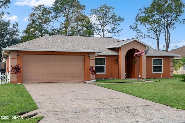 ranch-style home featuring a garage and a front lawn