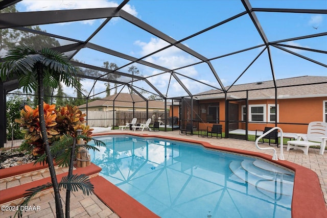 view of swimming pool with a lanai and a patio area