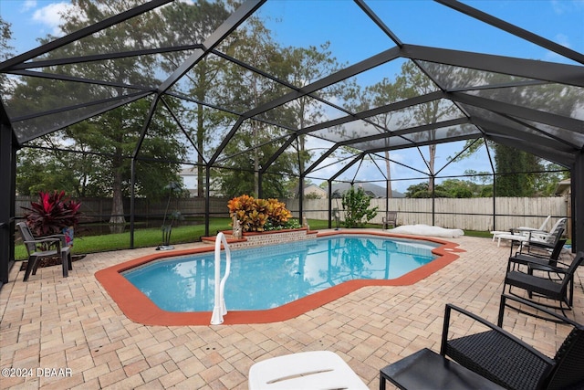 view of pool with glass enclosure and a patio area