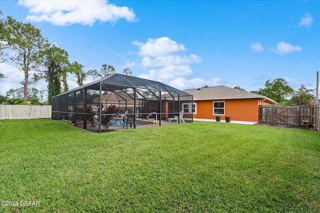 view of yard with a fenced in pool, glass enclosure, and a patio