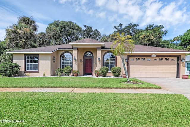 ranch-style home featuring a garage and a front yard