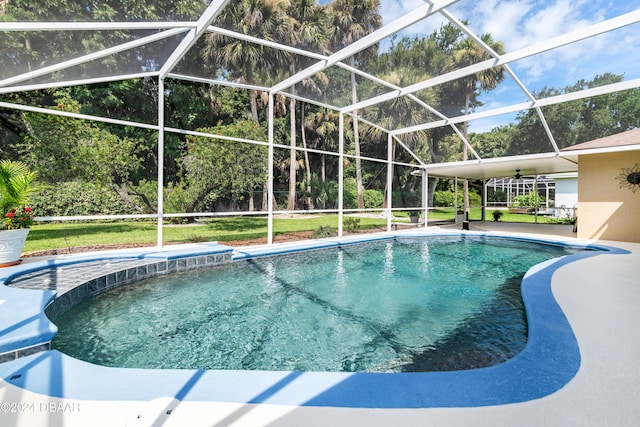 view of pool featuring ceiling fan, a patio area, a lanai, and a yard