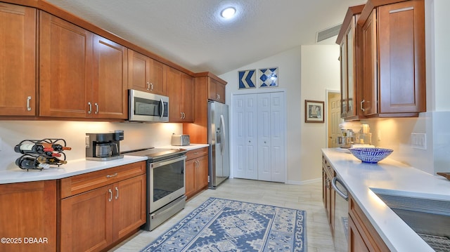 1453 Sunningdale Ln, Ormond Beach, FL 32174 - kitchen featuring brown cabinets, appliances with stainless steel finishes, lofted ceiling, and light countertops