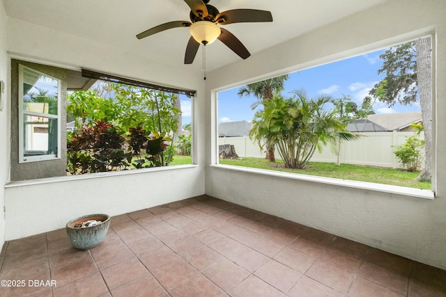 unfurnished sunroom with ceiling fan