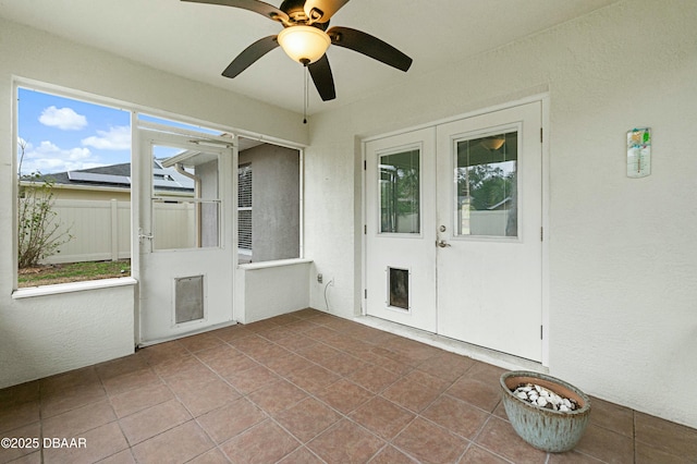 unfurnished sunroom featuring ceiling fan