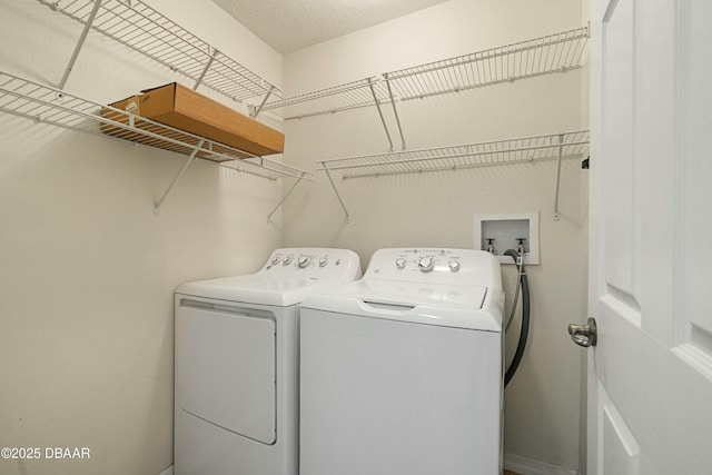 laundry area featuring a textured ceiling and washer and clothes dryer