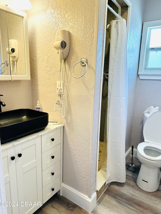 bathroom with toilet, wood-type flooring, vanity, and a shower with curtain