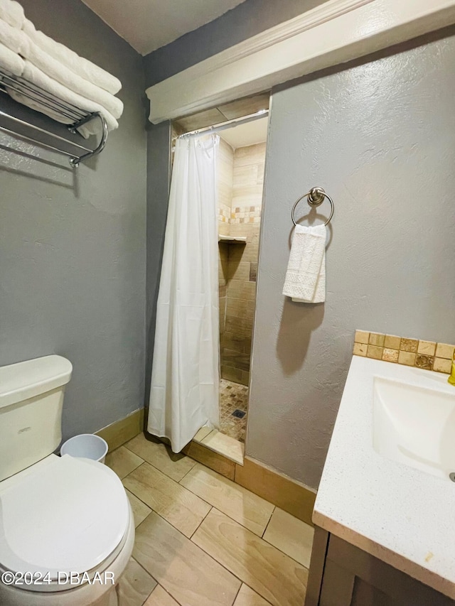 bathroom featuring vanity, toilet, and curtained shower