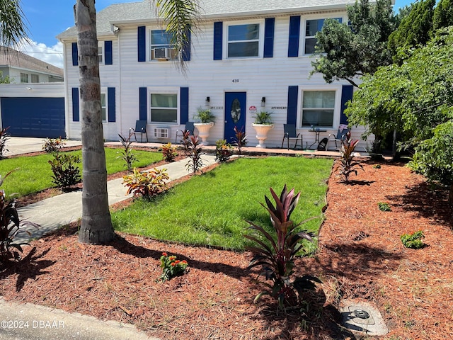 colonial home featuring cooling unit and a front lawn