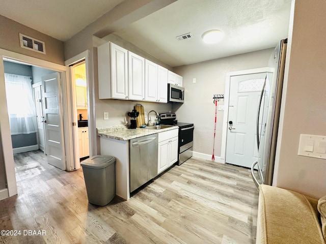 kitchen with sink, light wood-type flooring, white cabinetry, and stainless steel appliances