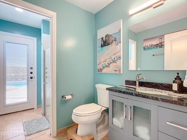 bathroom with vanity, toilet, walk in shower, and tile patterned floors