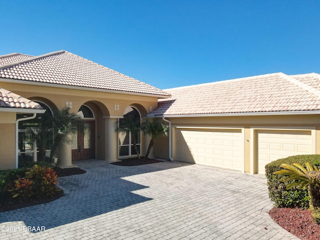 mediterranean / spanish-style house with a garage